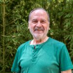 A man standing in front of a bamboo tree